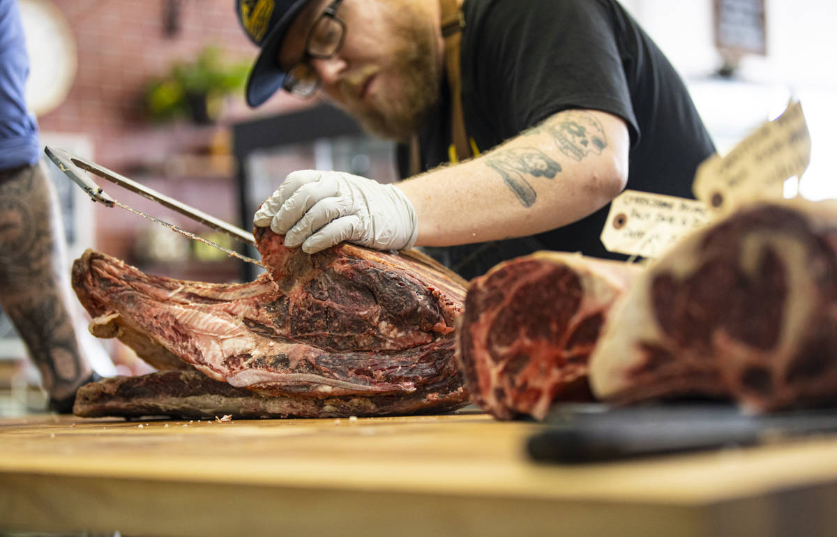 Apprentice Jimmy Henderson carves beef while being guided by Martin Kirrane, owner and butcher ...