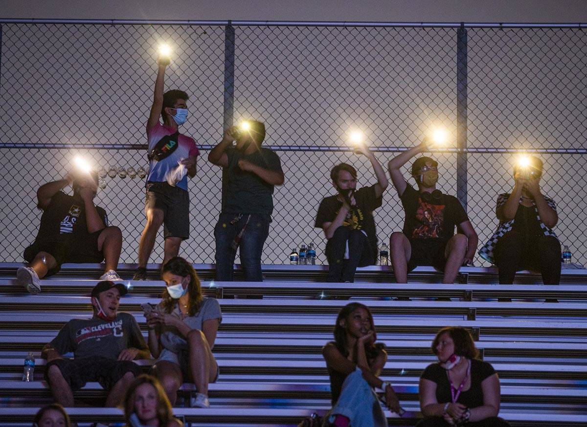 Students wave their phone lights as the Imagine Dragons perform at a Walmart-sponsored "Homecom ...