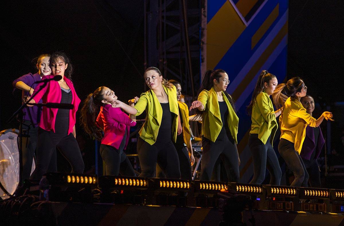 Students dance on stage as the Imagine Dragons perform at a Walmart-sponsored "Homecoming Conce ...