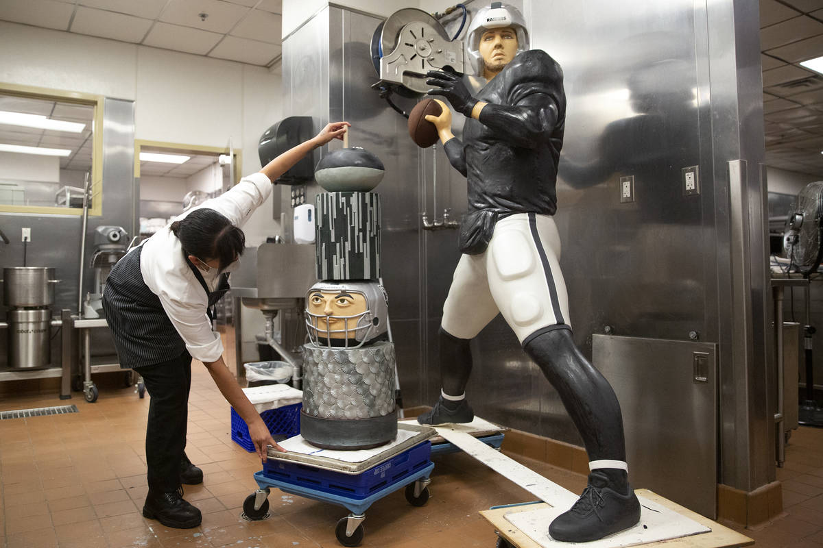 Aria assistant pastry chef Andy Madrid shows two of the finished cakes, including a life-size c ...