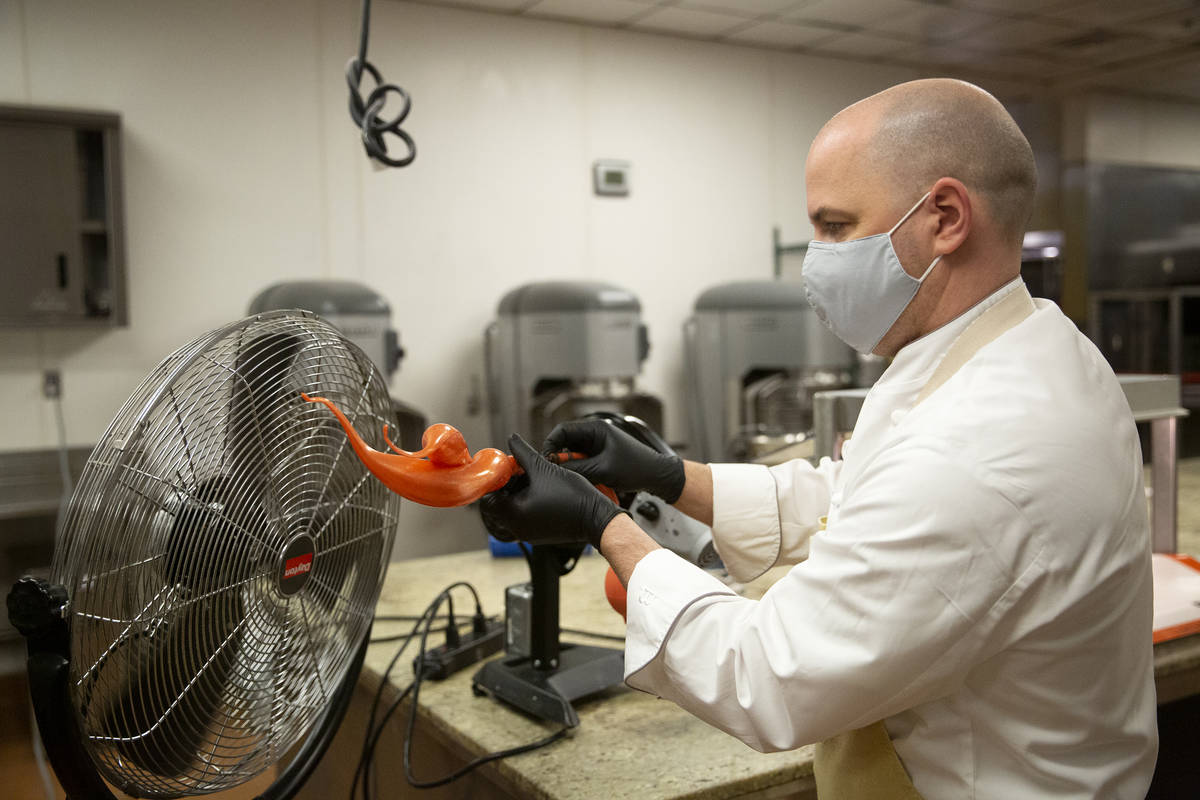 Executive pastry chef Mathieu Lavallee cools a blown sugar flame that will adorn the Raiders to ...