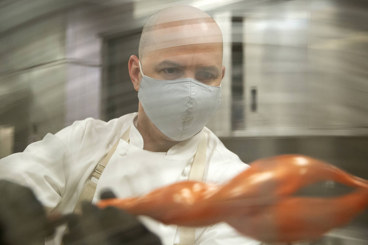 Executive pastry chef Mathieu Lavallee cools a blown sugar flame that will adorn the Raiders to ...