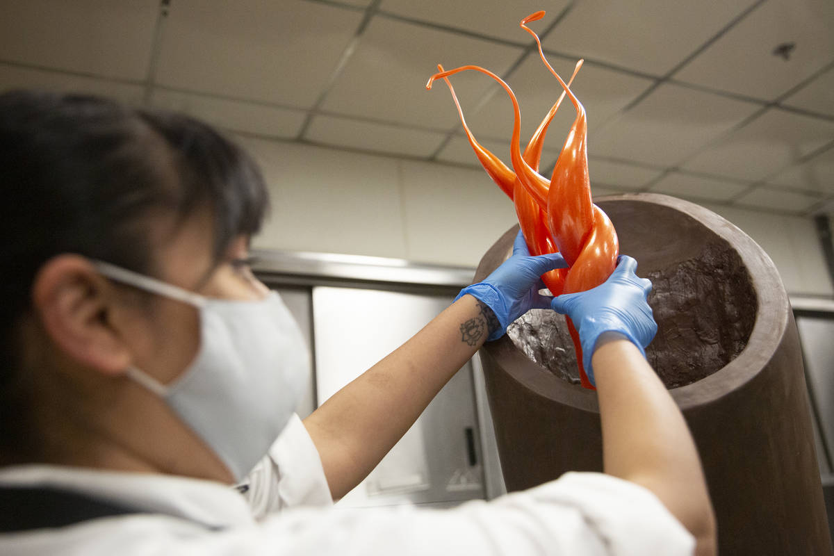 Aria assistant pastry chef Andy Madrid shows how the flames will fit in the Raiders torch made ...
