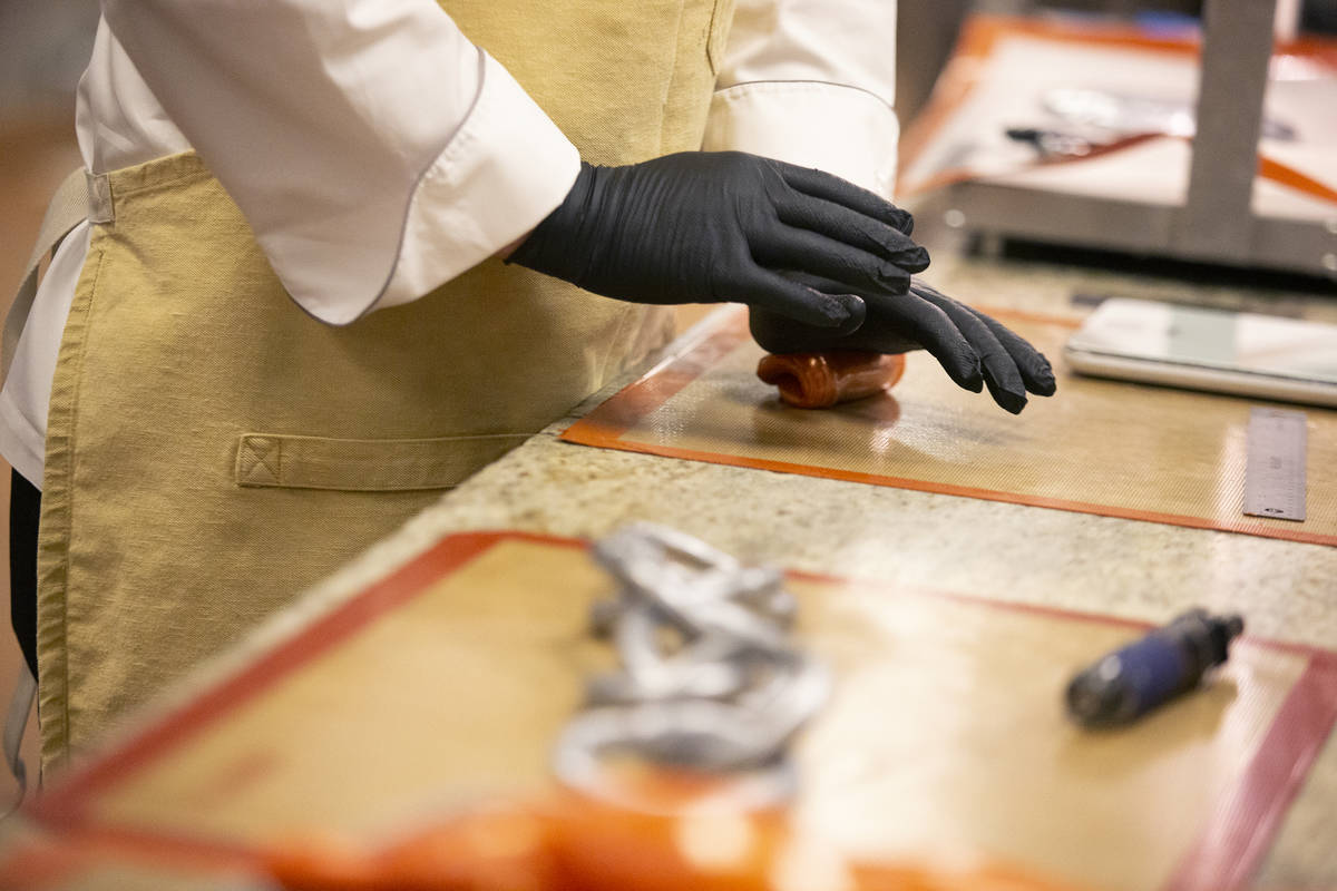 Executive pastry chef Mathieu Lavallee kneads the orange molten sugar that will become a flame ...