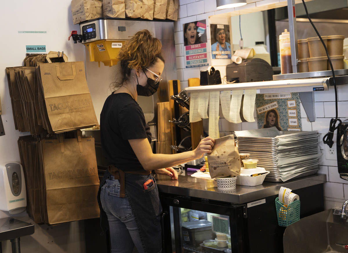Sandra Ruiz, Tacotarian manager, check out customers orders as she prepares them to be delivere ...