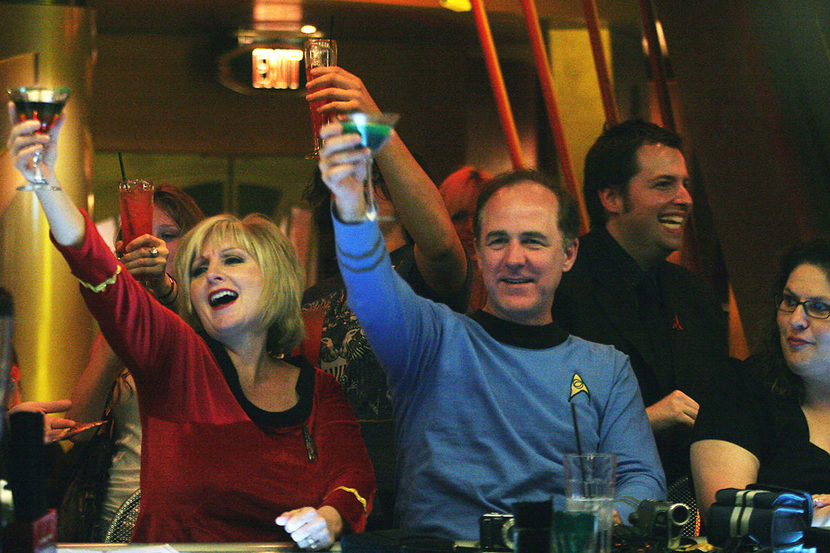 Wife and husband Star Trek fans Pat and Bill Lyons, visiting from Lincoln, Calif., raise their ...