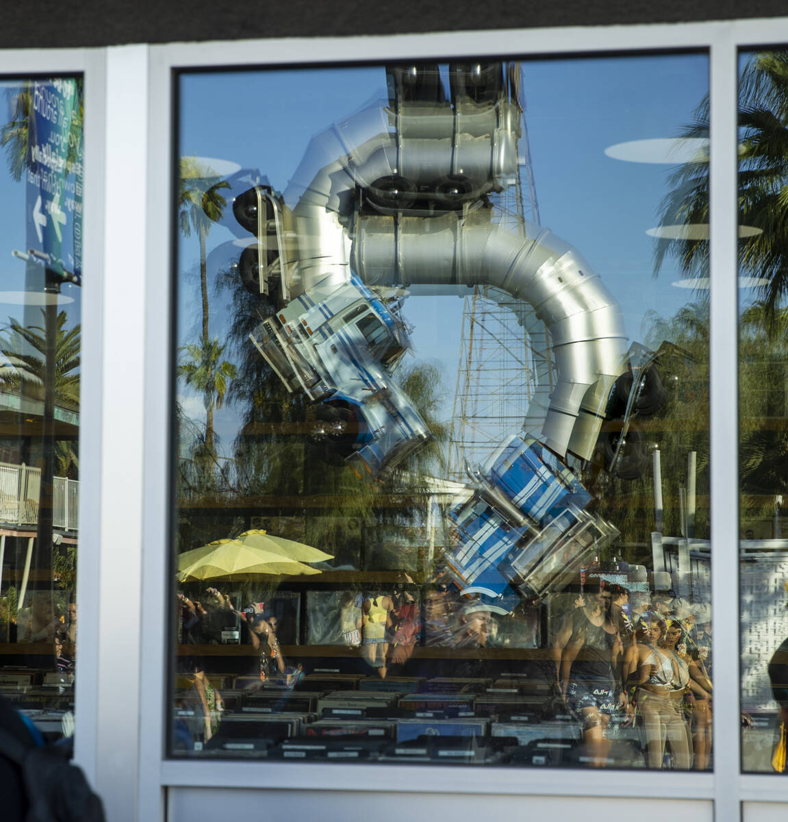 The Big Rig Jig at Fergusons is projected in a window as people walk along Fremont Street durin ...