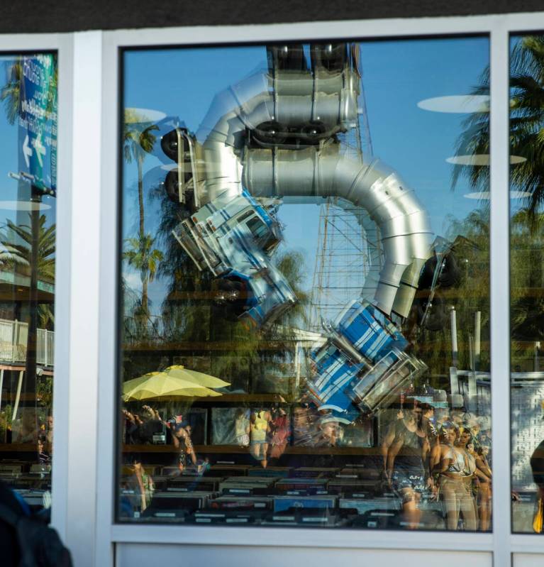 The Big Rig Jig at Fergusons is projected in a window as people walk along Fremont Street durin ...
