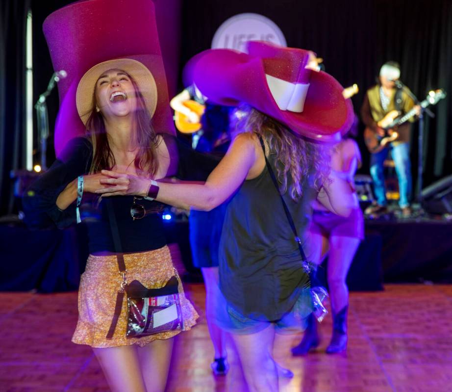 Beth Sassani, left, and Kellie Brunty dance with their big cowboy hats on as The Rhyolite Sound ...