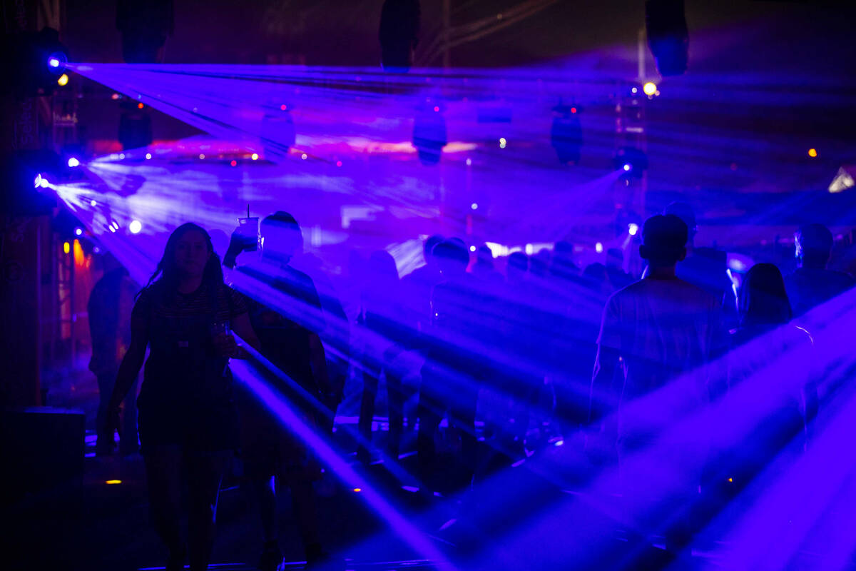 Attendees stream along Selects Astro Alley during day one of Life is Beautiful on Friday, Sept. ...