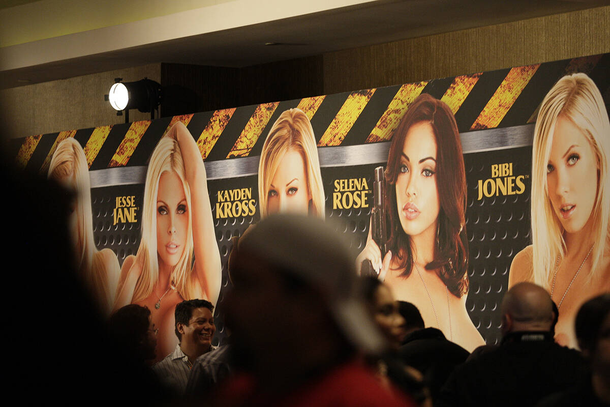Crowds walk past a banner advertising adult film stars at AVN's Adult Entertainment Expo at the ...