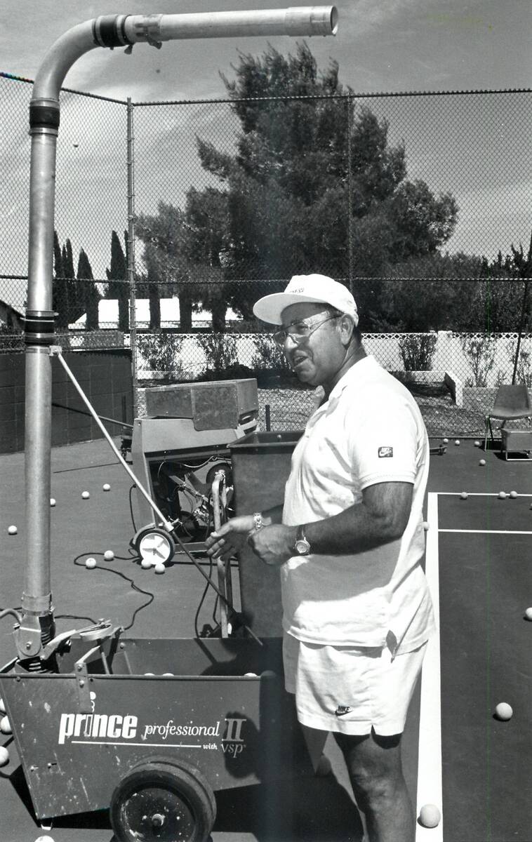 Mike Agassi, the father of Andre Agassi, loads and adjusts the ball machine used on the tennis ...