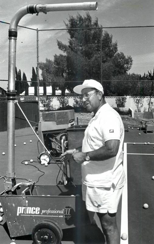 Mike Agassi, the father of Andre Agassi, loads and adjusts the ball machine used on the tennis ...