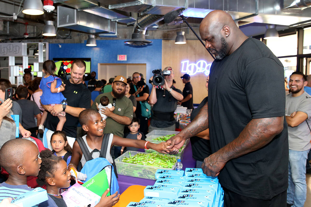 Mishawn Ricks, 9, of Las Vegas, shakes hands with former NBA star Shaquille O'Neal during Shaq- ...