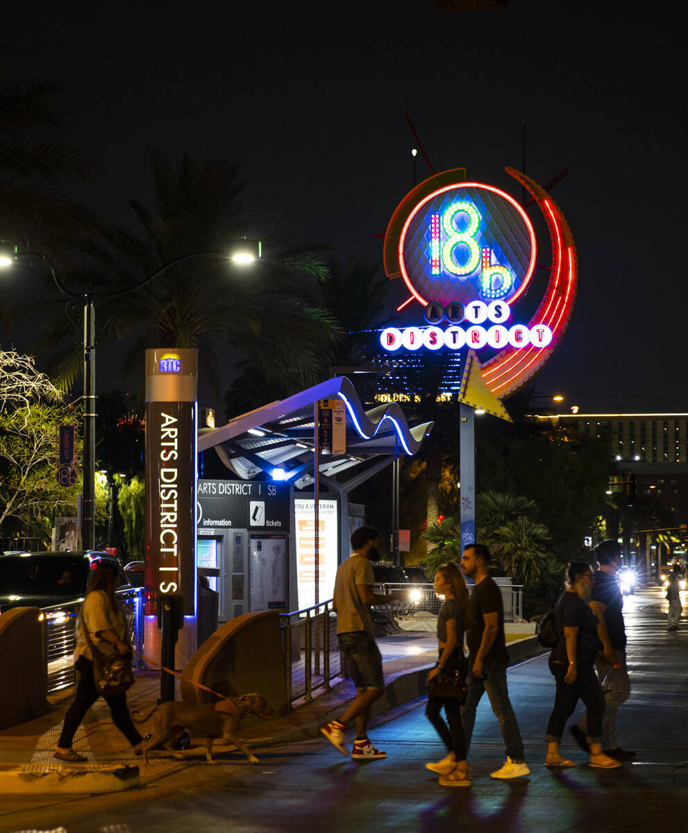 People cross the street near the 18B Arts District neon sign during First Friday in downtown La ...
