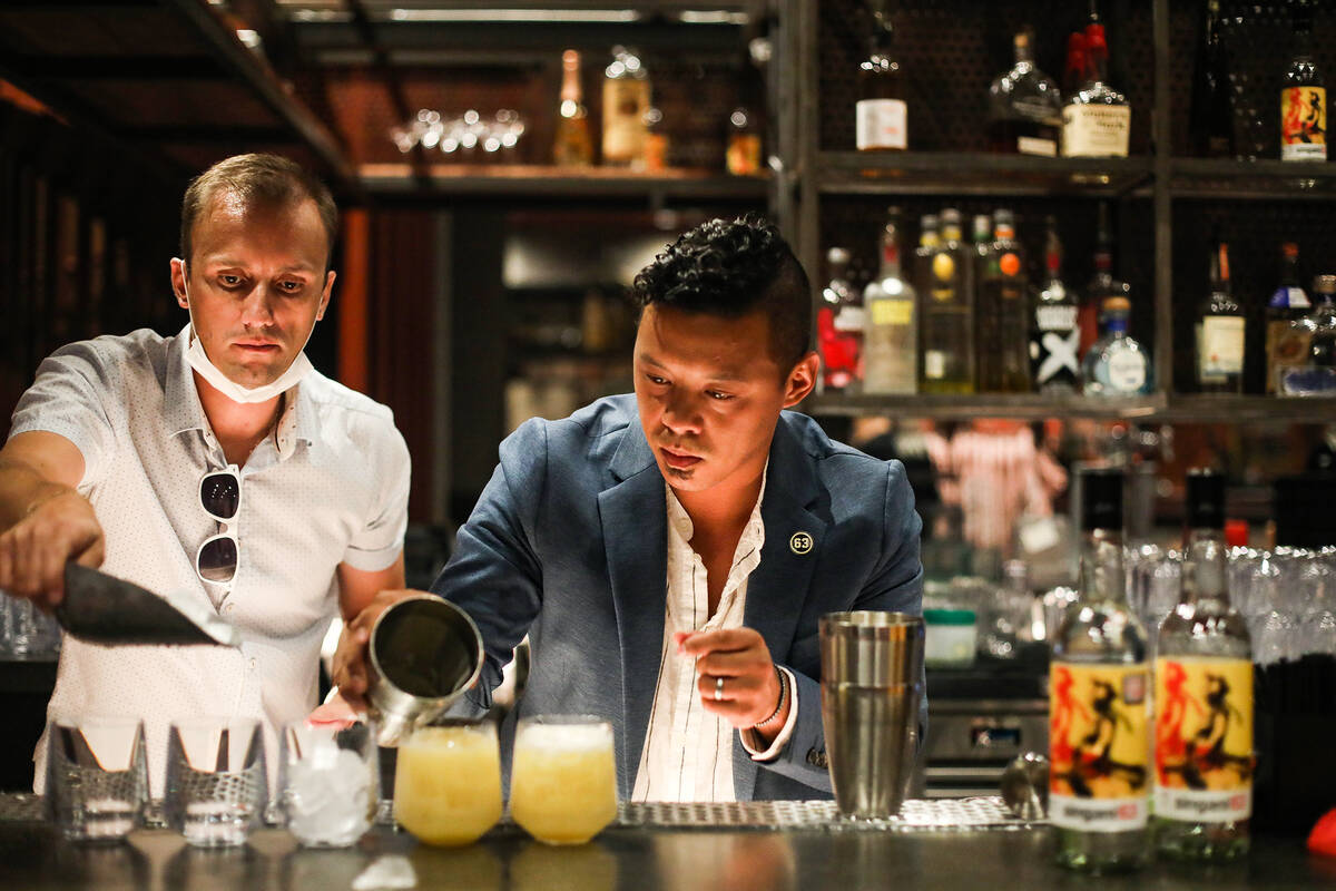 Enis Kola, director of day life and nightlife entertainment for the Sahara, left, assists Ricky ...