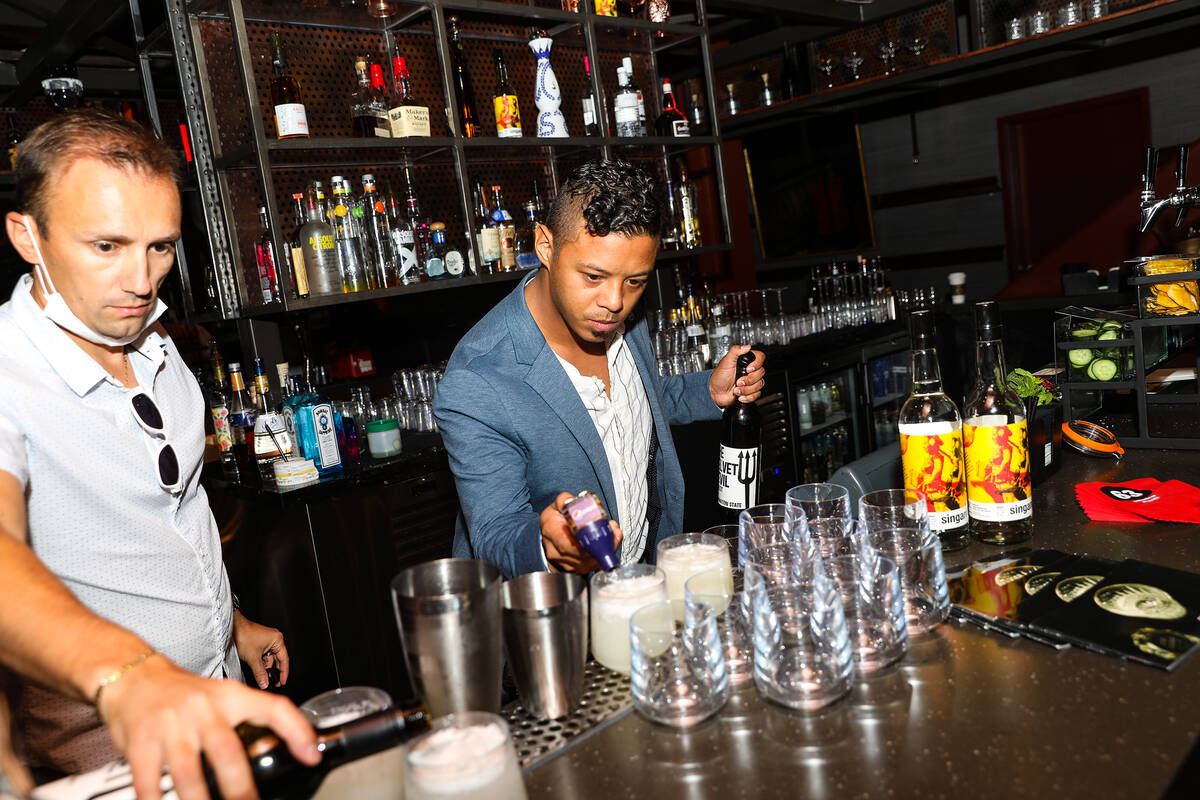 Ricky Lin, director of sales for Singani 63, right, creates a cocktail alongside Enis Kola, dir ...