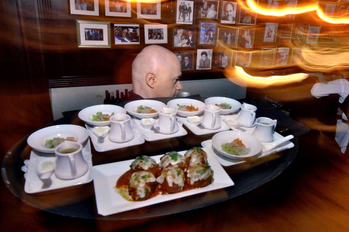 Waiter Davor Vidovic takes food to a table at Rao’s during Vegas Uncork’d festivities at Ca ...