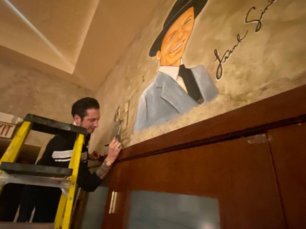Bandleader Brian Newman of Lady Gaga's orchestra is shown signing his sketch at Palm Restaurant ...