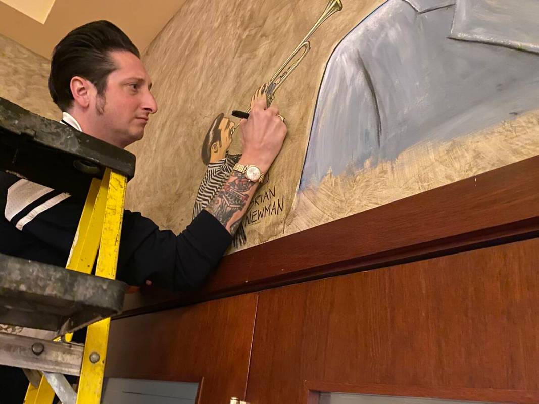 Bandleader Brian Newman of Lady Gaga's orchestra is shown signing his sketch at Palm Restaurant ...