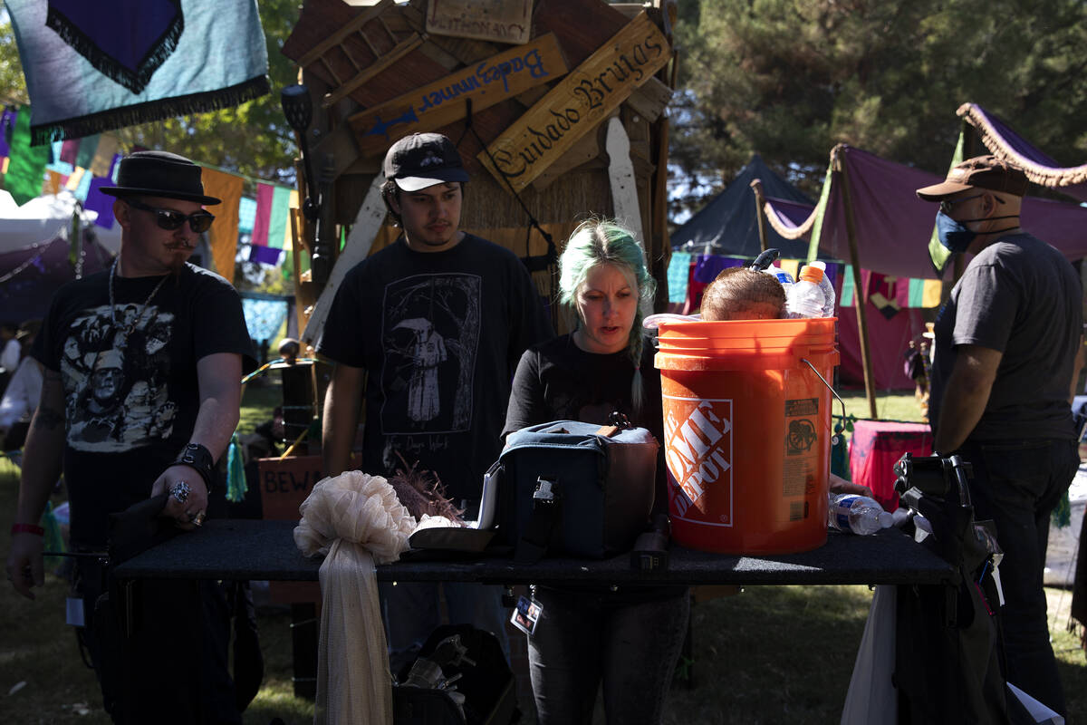 A film crew carries props, including a severed head inside a bucket, through the Age of Chivalr ...