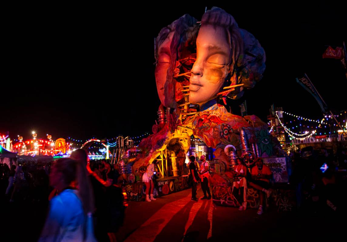 Attendees walk by an art installation during the second day of the Electric Daisy Carnival at t ...