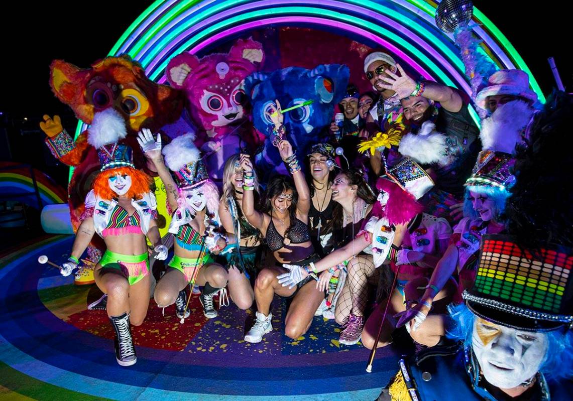 Costumed performers dance and take pictures with attendees during the first day of the Electric ...