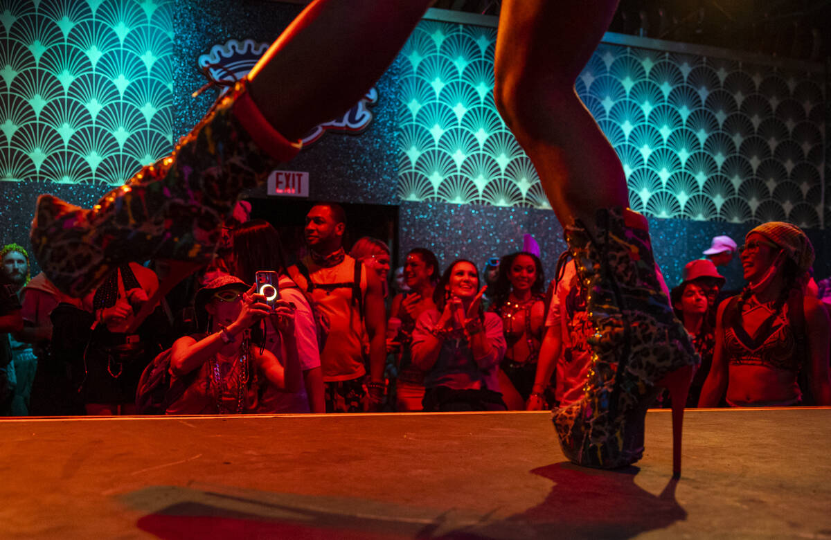 Attendees watch dancers at The Queen Bar during the first day of the Electric Daisy Carnival at ...