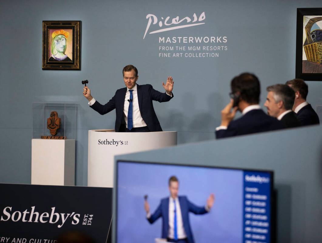 Oliver Barker, left, takes bids during an auction held by Sotheby's featuring eleven of Pablo P ...