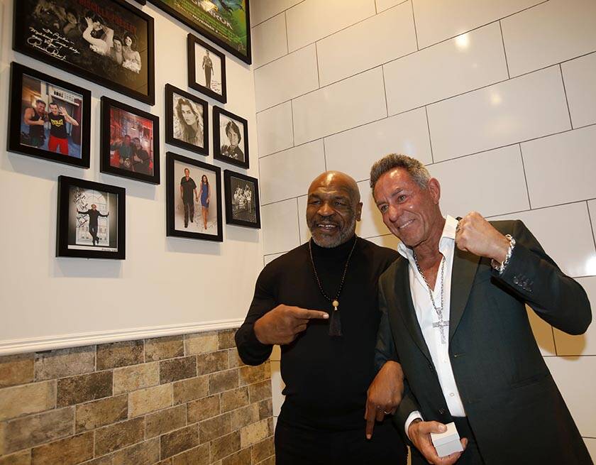 Former boxer Mike Tyson, left, poses for photos with Mulberry Street Pizzeria founder and owner ...