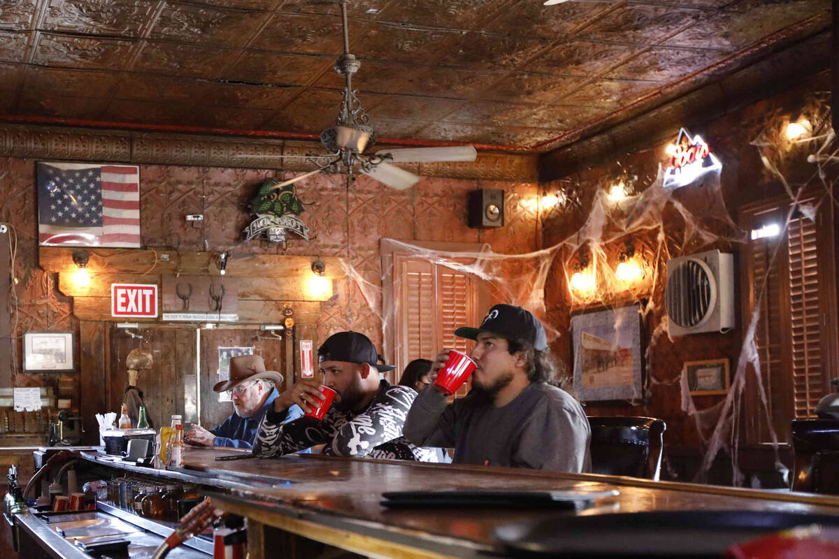 Erick Amaya of Las Vegas, left, drinks with his friend Jose Furlong of Las Vegas, right, in the ...