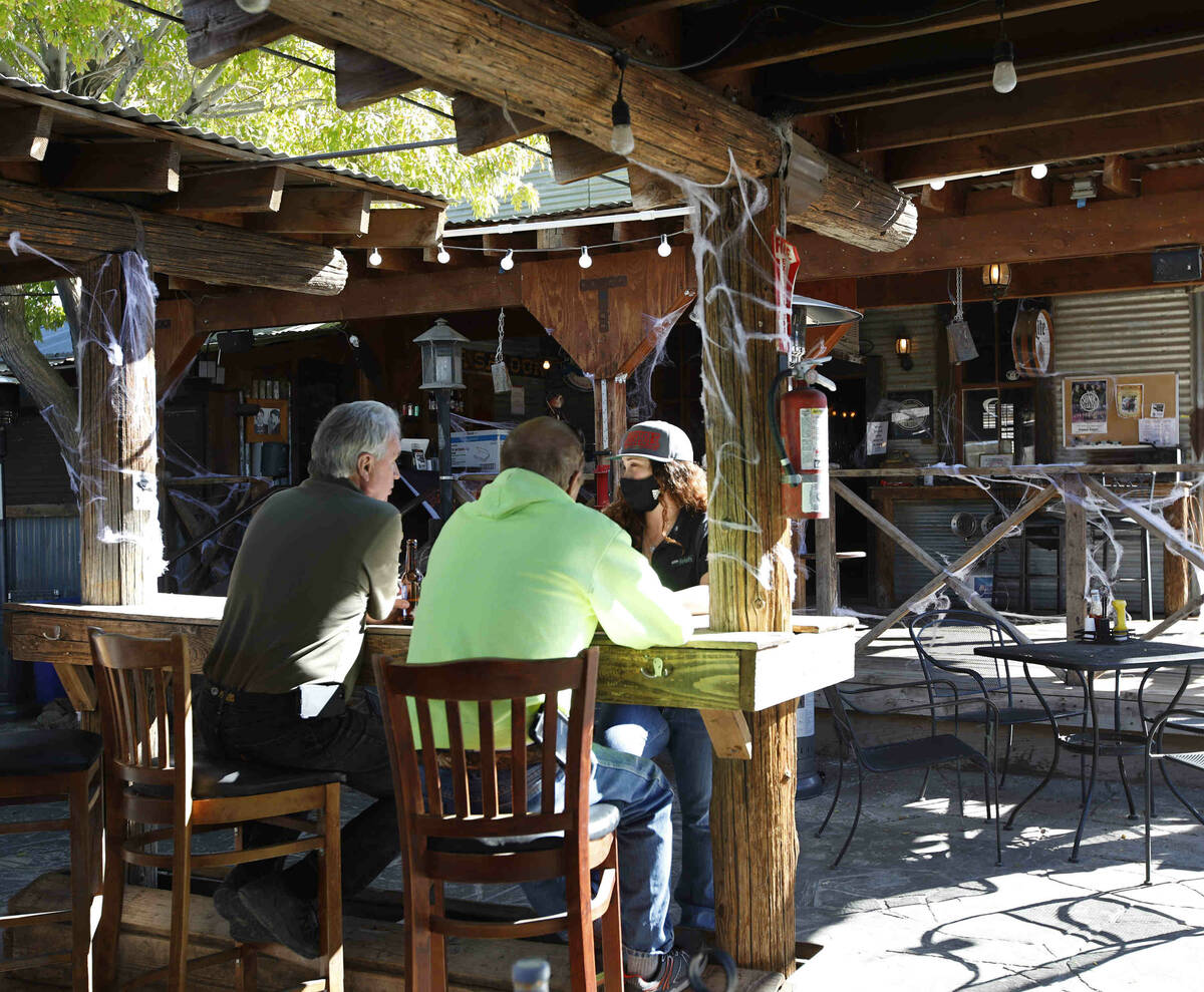 Bartender Kristi Cristiano talks with her customers Dan Van Horn of Las Vegas, left, and his br ...