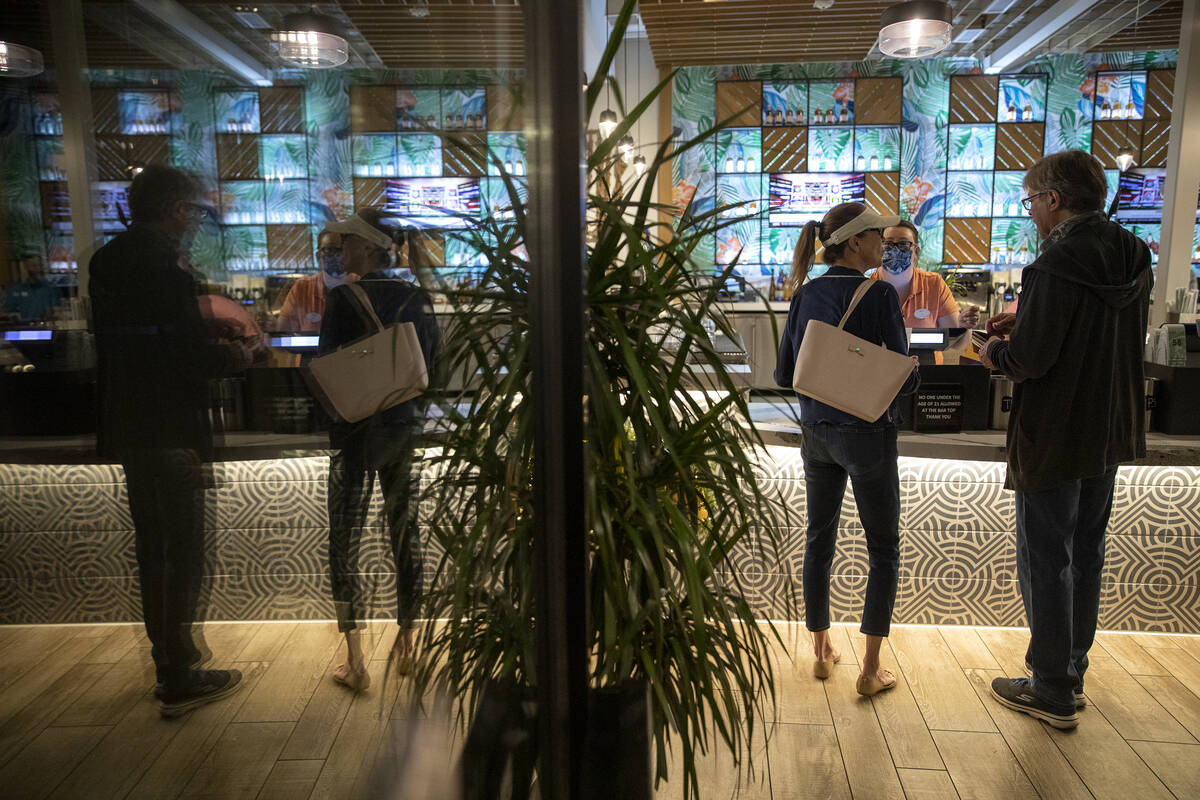 Bartender Jess Lilley takes customers' order at Tommy Bahama Marlin Bar & Store in Town Square ...