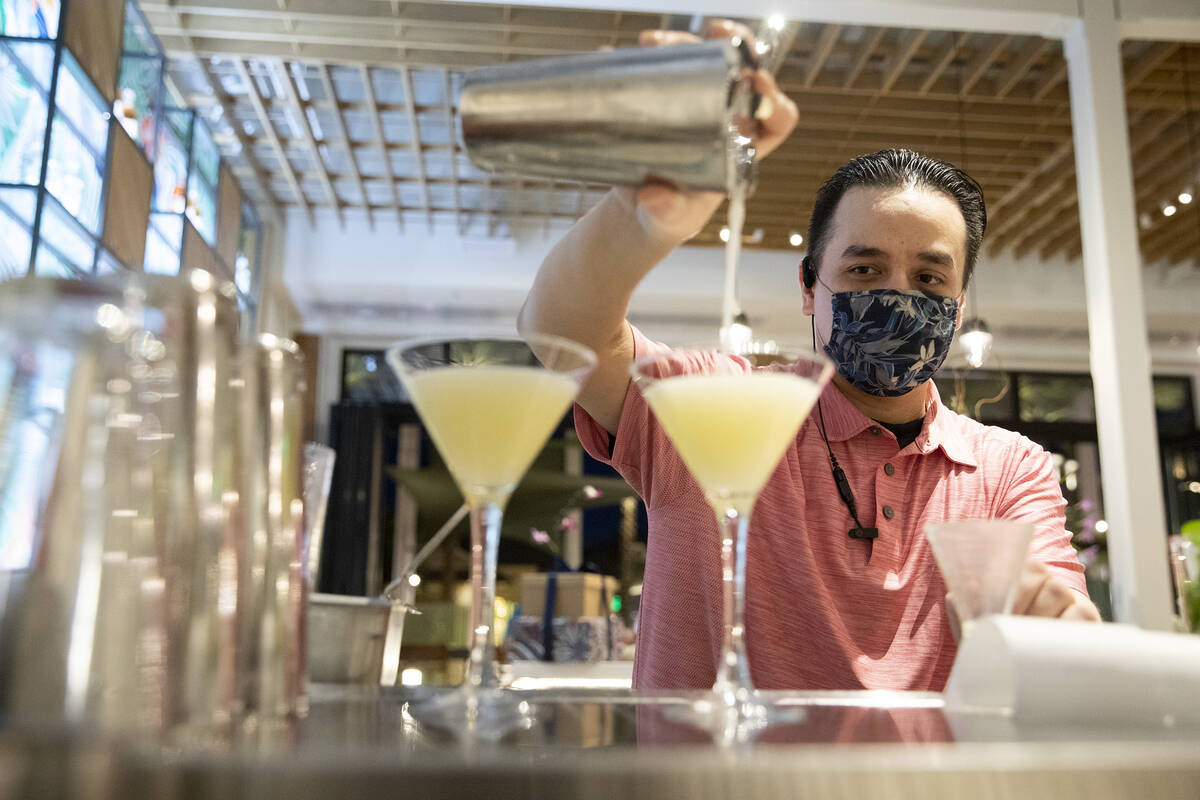Bartender Darrell Cliff pours a Pineapple Paradisio cocktail at Tommy Bahama Marlin Bar & Store ...