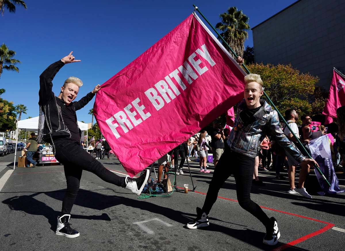 Twins Edward, right, and John Grimes of Dublin, Ireland, hold a "Free Britney" flag o ...