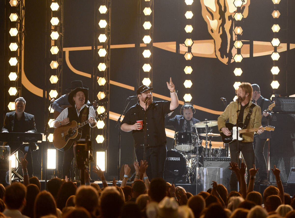 Kix Brooks, left, and Ronnie Dunn, right, of Brooks & Dunn, and Luke Combs perform "Brand New M ...