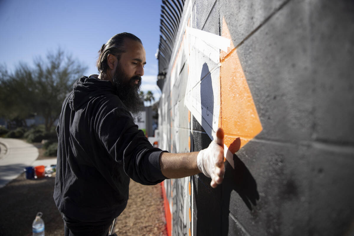 Ali Fathollahi works on a mural outside of the Neon Museum North Gallery in Las Vegas, Tuesday, ...