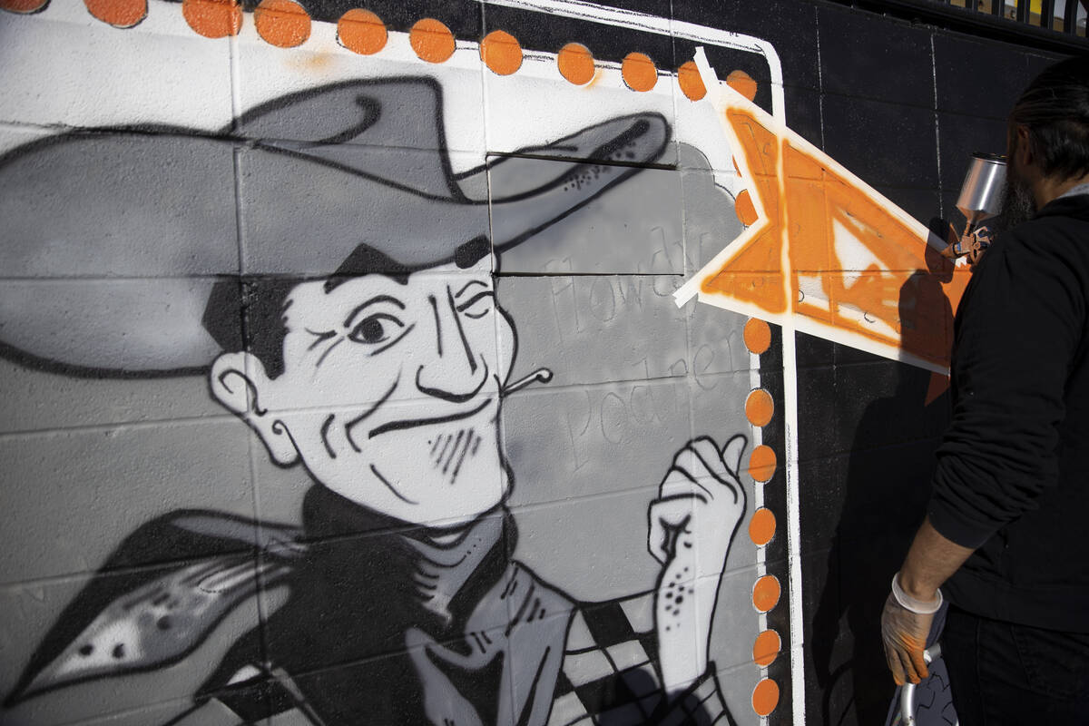 Ali Fathollahi works on a mural outside of the Neon Museum North Gallery in Las Vegas, Tuesday, ...