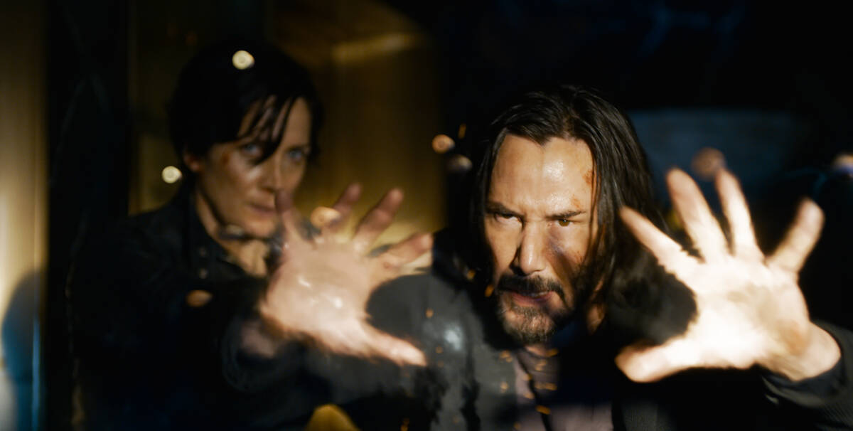 Carrie-Anne Moss as Trinity and Keanu Reaves as Neo/Thomas Anderson in “The Matrix Resurrecti ...