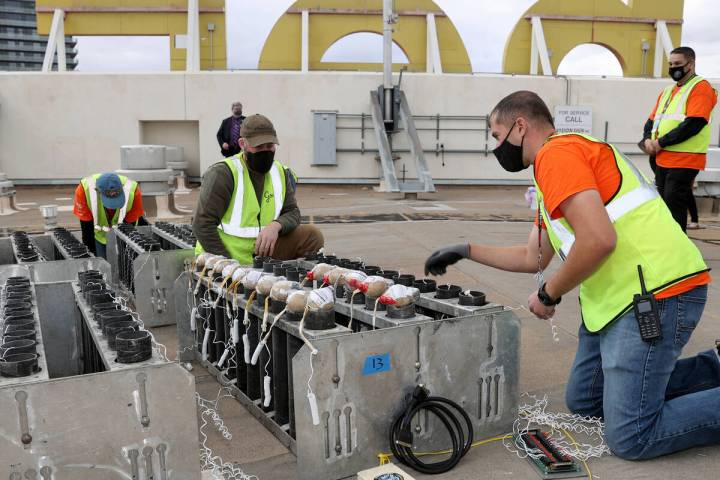 Pyro technicians with Fireworks by Grucci Justin Presny, right, and Michael Esposito load pyrot ...