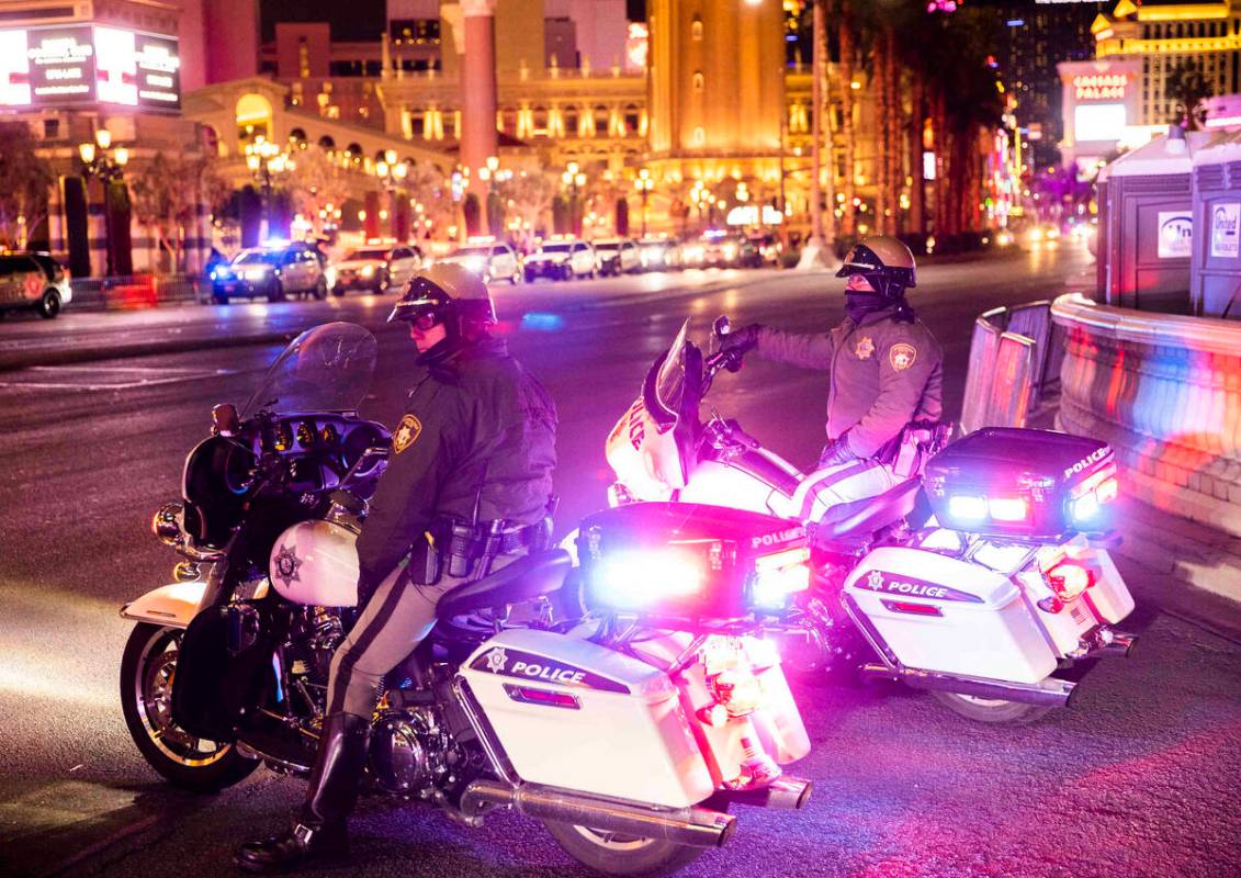 Law enforcement watch New Year’s Eve crowds walk the Strip on Friday, Dec. 31, 2021, in ...