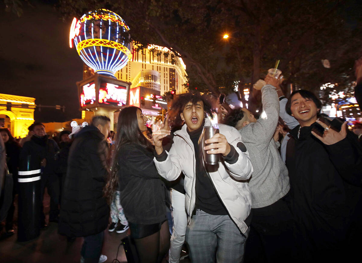 People dance on the Las Vegas Strip, Friday, Dec. 31, 2021, in Las Vegas, during the New Year's ...
