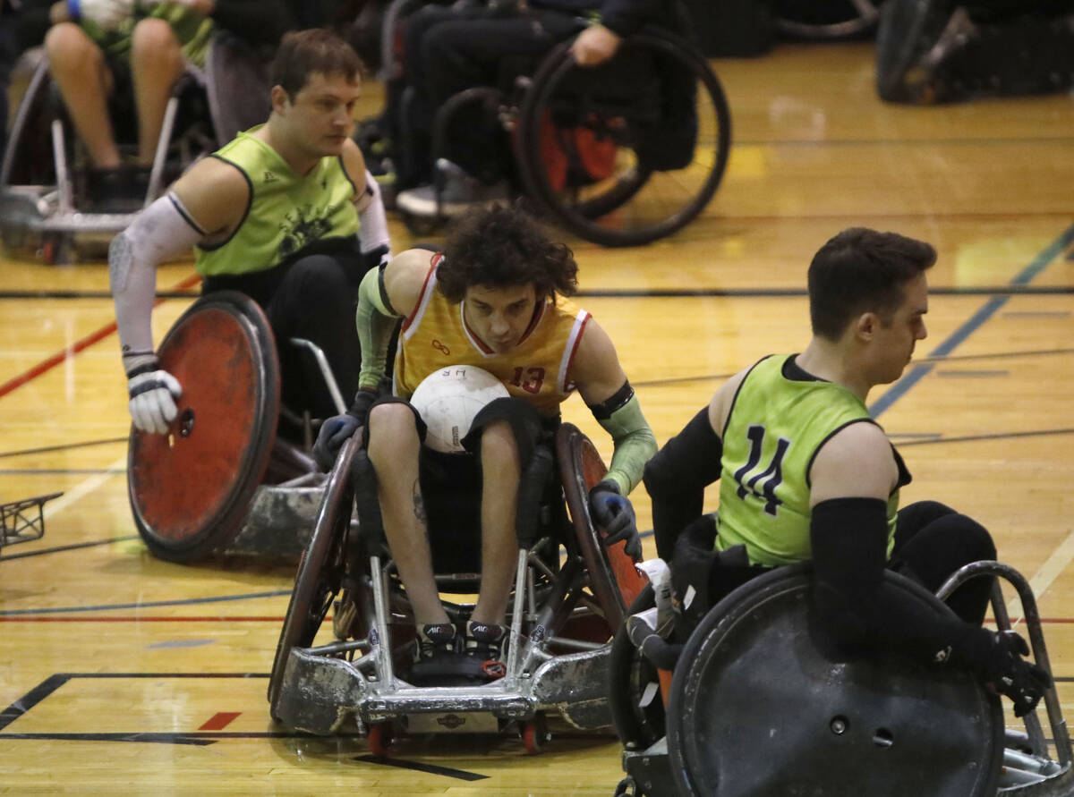 Las Vegas High Rollers' CJ Brown (13), center, carries a ball passing through Seattle Slam's Br ...