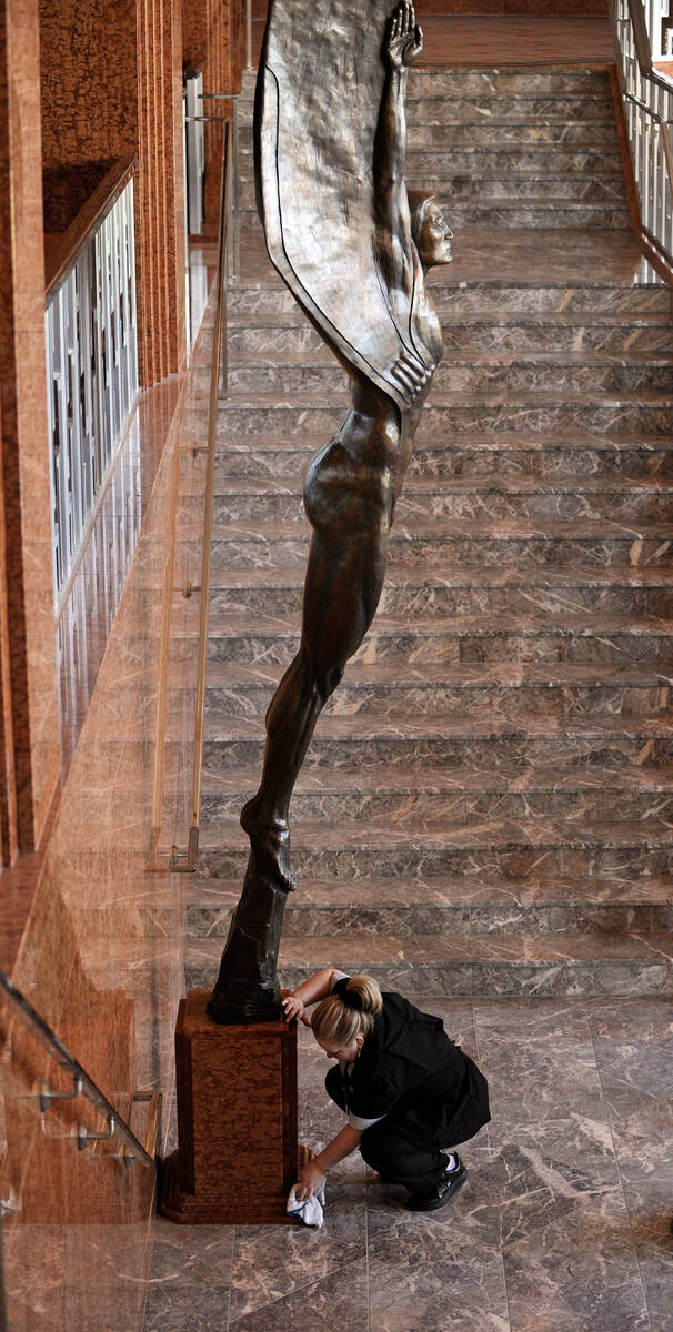 Housekeeper Olga Oropeza cleans up the base of artist Benjamin Victor's sculpture after its ins ...