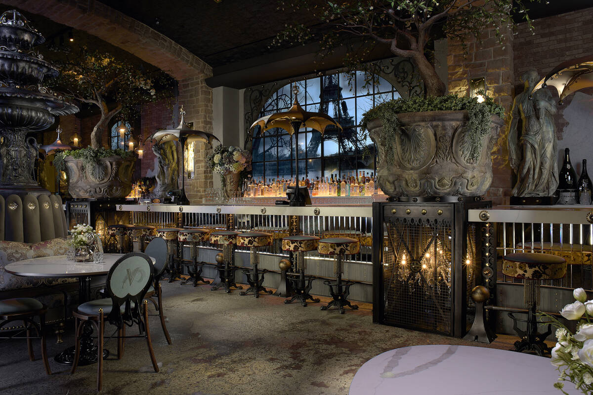 Windows behind the bar overlook the Eiffel Tower and the Seine River. Water streams behind the ...