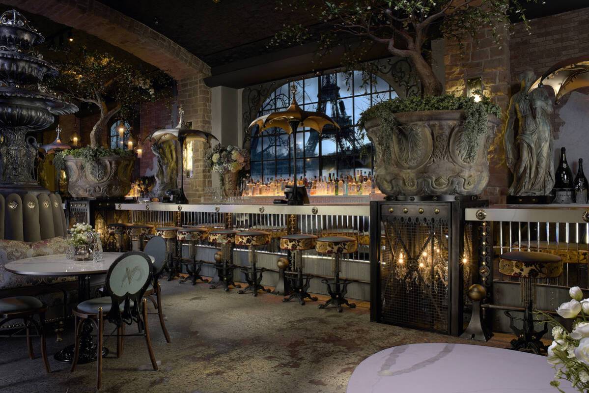 Windows behind the bar overlook the Eiffel Tower and the Seine River. Water streams behind the ...