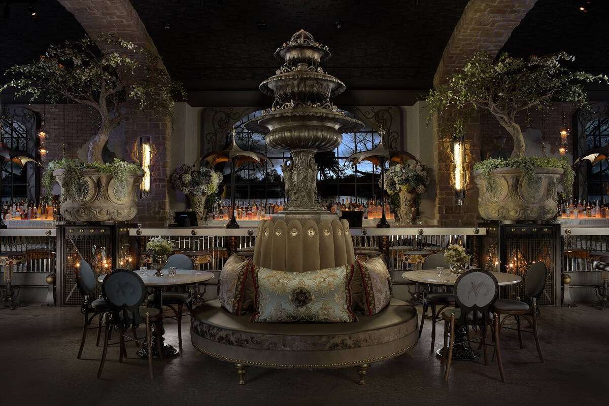 The space features multiple seating areas, including velvet banquettes with embellished pillow ...