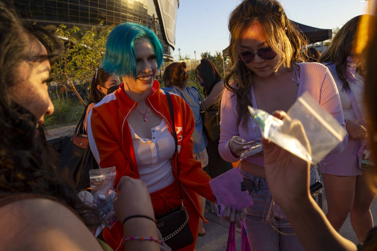 Mariah Leckliter, second from left, of Arizona, hands out free, handmade bracelets and stickers ...