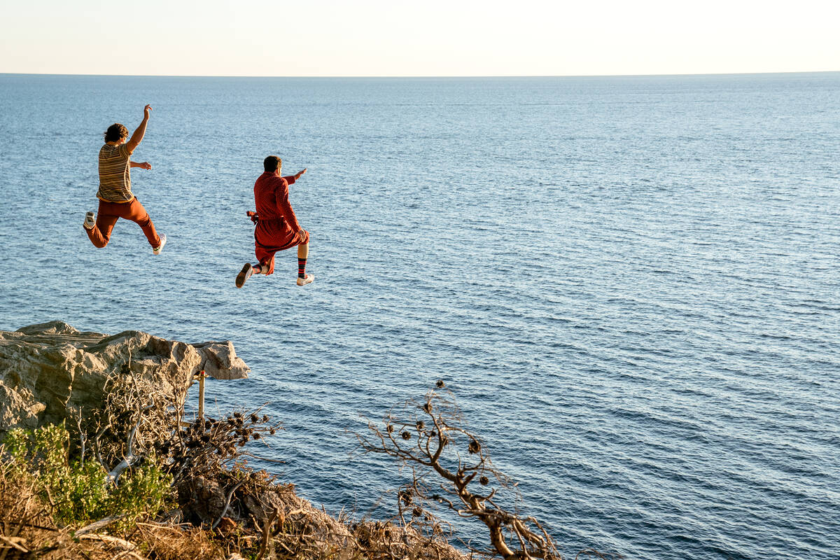 Pedro Pascal as 'Javi Gutierrez' (left) and Nicolas Cage as 'Nicolas Cage' cliff diving into th ...