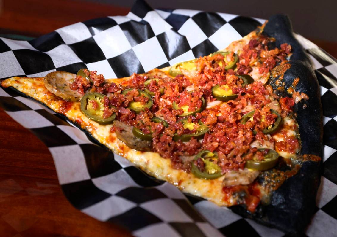 A slice of Murder Pie with toppings is seen at Sliced Pizza, Sunday, May 8, 2022, in Las Vegas. ...